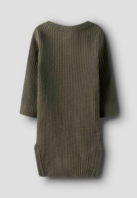 Abito in cotone verde oliva a coste, con maniche lunghe, scollatura rotonda e spacchi laterali per facilitare il movimento. La superficie testurizzata è evidente.