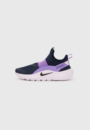 Nike-sneaker med svart og lilla overdel, glatt tekstur, elastisk design og en hvit spraglet såle med en svart logo.