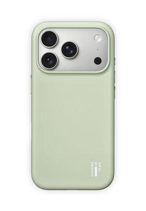 Coque de téléphone vert clair étiquetée "Ideal of Sweden" protégeant un smartphone avec trois caméras arrière et un flash sur un panneau argenté.