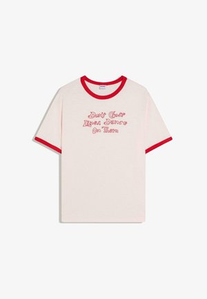 Fehér póló piros szegéllyel az ujjakon és a galléron, vidám betűtípussal, piros szöveggel: "Ne lépd át a vonalakat, táncolj rajtuk".