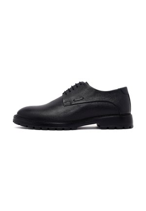 Zapatos de vestir de cuero negro con una textura lisa, diseño de cordones, punta redondeada y suela de goma duradera. Acentos minimalistas.