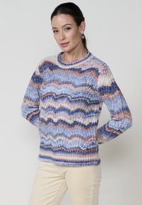 Pull en tricot en laine douce et multicolore avec des motifs en zigzag dans des nuances de bleu, rose et crème ; encolure ras du cou et coupe décontractée.