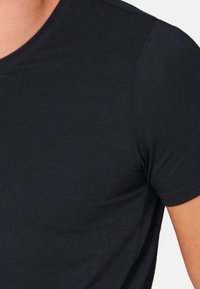 Dunkelnavyblaues T-Shirt mit kurzen Ärmeln und Rundhalsausschnitt; glatte Textur und schlichtes Design, ohne sichtbare Logos oder Muster.