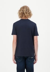 Navy blue short-sleeve t-shirt with a classic crew neckline, made of soft fabric, displayed from the back against a plain white background.