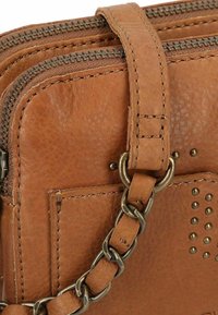 Borsa in pelle marrone con due scomparti con zip, dotata di una tracolla a catena e dettagli in borchie sui lati per un tocco di stile e texture.