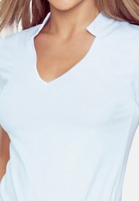 Jasnoniebieska bluzka z krótkim rękawem, z dekoltem w serek i unikalnym wzorem kołnierza. Gładka faktura, dopasowany krój, bez widocznych wzorów czy akcentów.