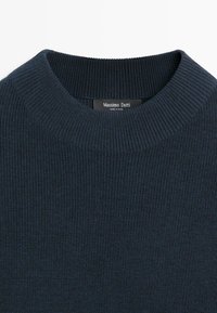 Granatowy prążkowany sweter z okrągłym dekoltem i fakturowaną tkaniną. Metka z napisem "Massimo Dutti", co wskazuje na markę.