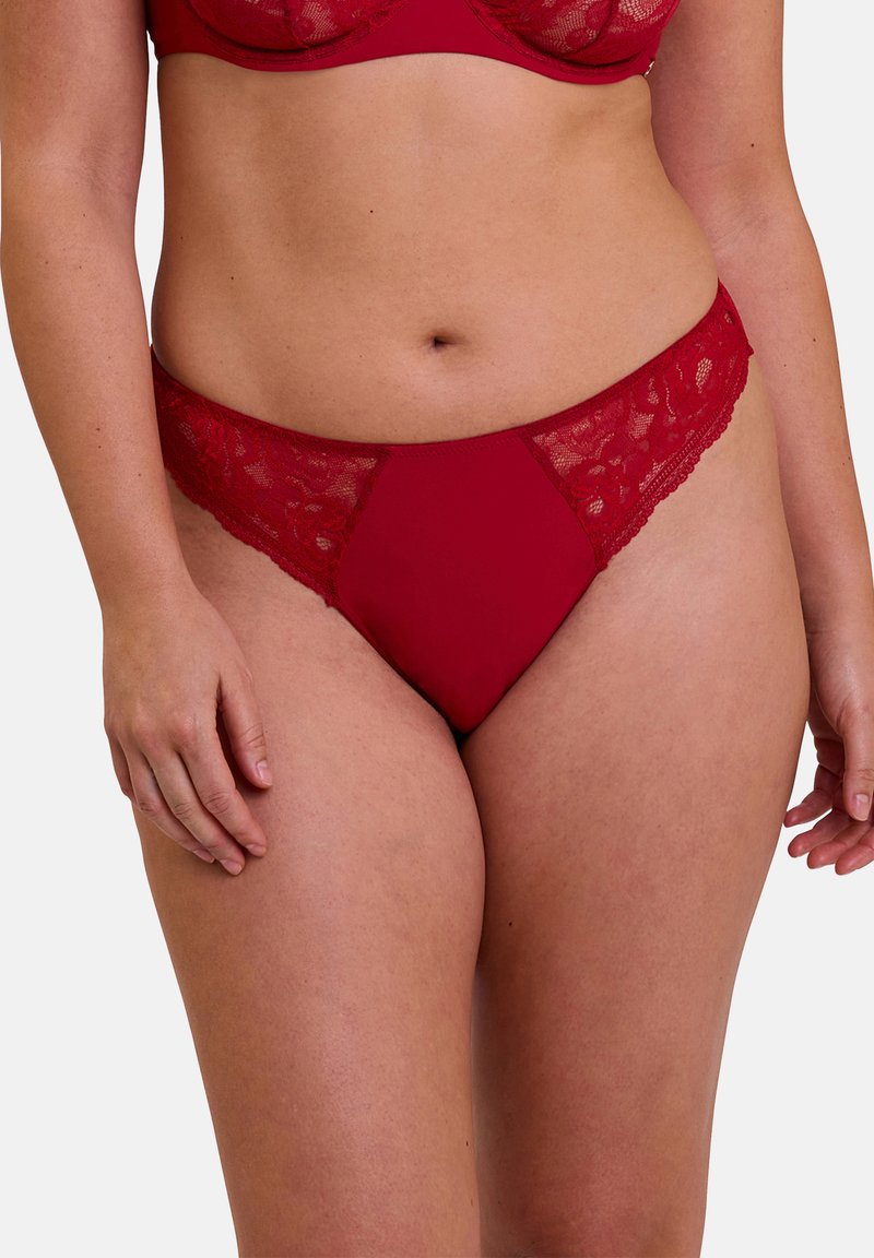 Sous-vêtements rouge avec bordure en dentelle, présentant un corps lisse et des côtés en dentelle transparente, un design échancré et une taille élastique pour le confort.