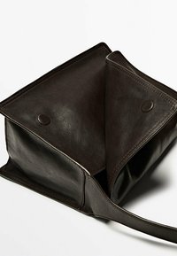 Brun lædertaske med et åbent, rummeligt indre. Har to trykknaplukninger og en glat tekstur, der fremhæver rene linjer og minimalistisk design.