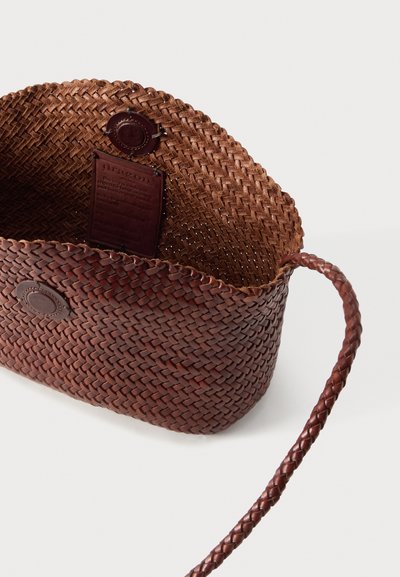 Καφέ πλεκτή δερμάτινη τσάντα με στρογγυλό πλεκτό λουρί, ανοιχτή κορυφή και δερμάτινη ετικέτα προσαρτημένη μέσα στην τσάντα.