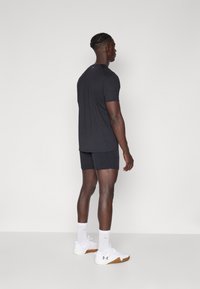 Zwarte sport t-shirt en shorts, strakke pasvorm met korte mouwen, gecombineerd met witte sportschoenen en sokken, eenvoudige textuur, minimale details.