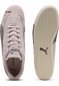 Tenisi Puma în roz deschis și gri închis din suede, cu o talpă texturată și un design cu șireturi, având branding embosat pe lateral.