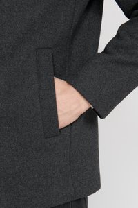 Grau melierter Wollmischmantel mit weicher Textur, ausgestattet mit einer Seitentasche und schlanker Passform. Der Ärmel hat ein klares, minimalistisches Design.