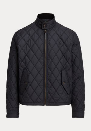 Sötétkék steppelt dzseki magas gallérral, cipzárral záródik, és két elülső zsebe gombos díszítéssel rendelkezik. Könnyű nylon anyagból készült.