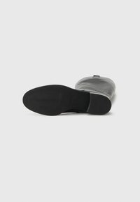 Sorte skinn ankle boots med en glatt overflate, avrundet tå og teksturert gummisåle. Har en løkkebånd bak for enkel påkledning.