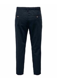 Pantaloni blu navy dal taglio slim, dotati di due tasche posteriori e piccoli bottoni marroni. Realizzati in un morbido tessuto testurizzato.