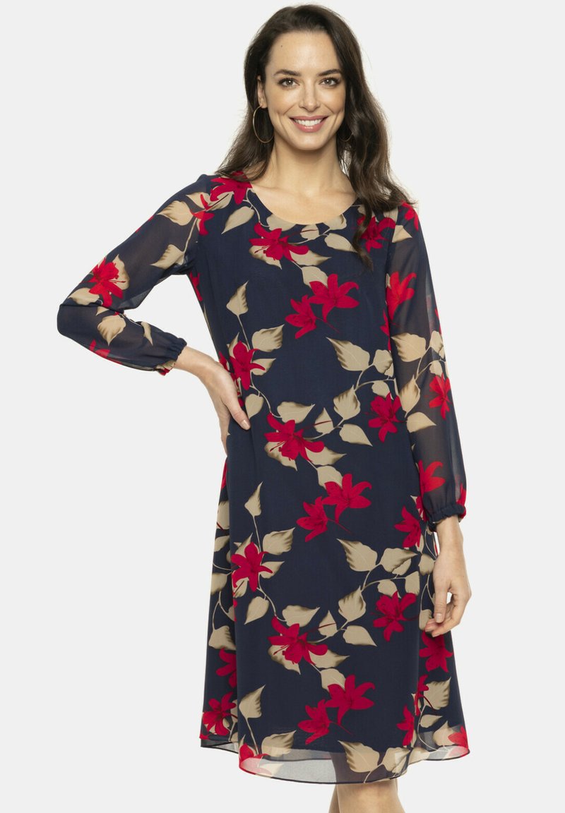 Granatowa sukienka z długimi, przezroczystymi rękawami. Posiada kwiatowy wzór w kolorze czerwonym i beżowym. Miękki, zwiewny materiał z okrągłym dekoltem i luźnym krojem.