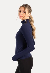Marineblauw lange mouwen top met hoge kraag, gemaakt van rekbaar materiaal, met een getailleerd ontwerp en duimopeningen bij de manchetten.