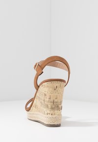 Bruine suede wedge sandaal met een kurken hak en jute omhulsel, met een smalle enkelband en een gladde, licht glanzende zool.