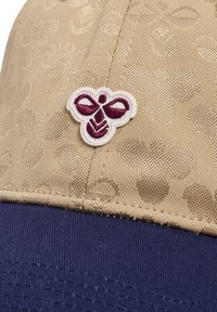 Beige Kappe mit einem strukturierten Blumenmuster, das ein weinrotes und weißes gesticktes Bienenlogo auf der Vorderseite und einen marineblauen Schirm aufweist.