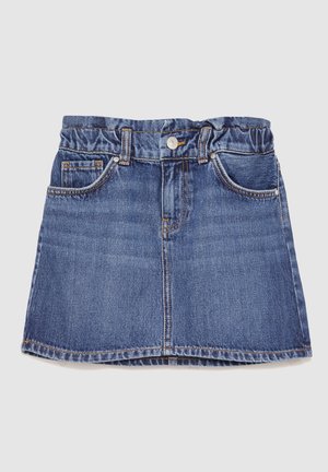 Blauwe denimrok met elastische tailleband, voor knoop en zakken, plat gelegd op een lichte achtergrond