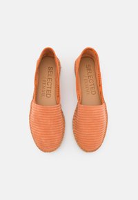 Kaks oranžiraitaista espadrillesia, joissa on ommellut pohjat ja "SELECTED / FEMME" -painatus sisäpohjissa, kuvattuna ylhäältä valkoista taustaa vasten.