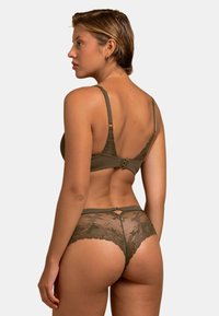 Ensemble de lingerie en dentelle kaki comprenant un soutien-gorge à coussinets avec broderie florale et bretelles réglables, associé à une culotte taille haute en transparent assortie.