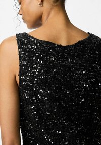 Czarny top bez rękawów pokryty cekinami, z okrągłym dekoltem i teksturowanym materiałem. Widoczne białe cekiny tworzą efekt błysku.