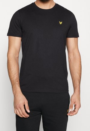 Camiseta negra de algodón con escote redondo, mangas cortas y un pequeño logo bordado en amarillo en el pecho. Diseño sencillo y clásico.