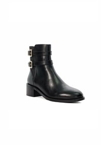 Bottine noire en cuir avec deux boucles latérales, un bout arrondi, une texture lisse et un petit talon carré.