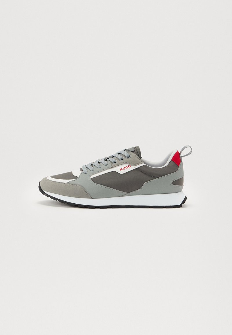 Men's sneakers in gray tones, featuring a mix of suede and mesh. Design includes a white midsole and red accent on the heel.