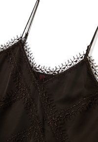 Camiseta sin mangas de color marrón oscuro con un delicado encaje en el escote y las costuras, que cuenta con finas tirantes ajustables.