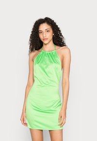 Vestido halter verde em satin com decote franzido e silhueta ajustada, exibindo uma textura suave e comprimento acima do joelho.