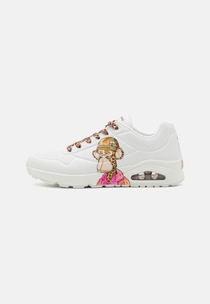 Weißer Sneaker mit Leopardenmuster-Schnürsenkeln und einer Grafik eines Schimpansen, der einen Tarnhelm und einen pinken Mantel trägt, an der Seite.