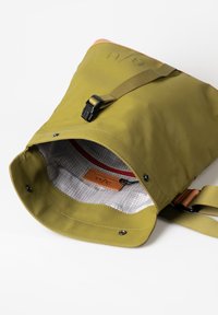 Grüner wasserdichter Sack mit Rolltop-Design, sicherem Schnallenverschluss und Innenrastermuster. Verfügt über ein Lederlabel und einen verstellbaren Gurt.