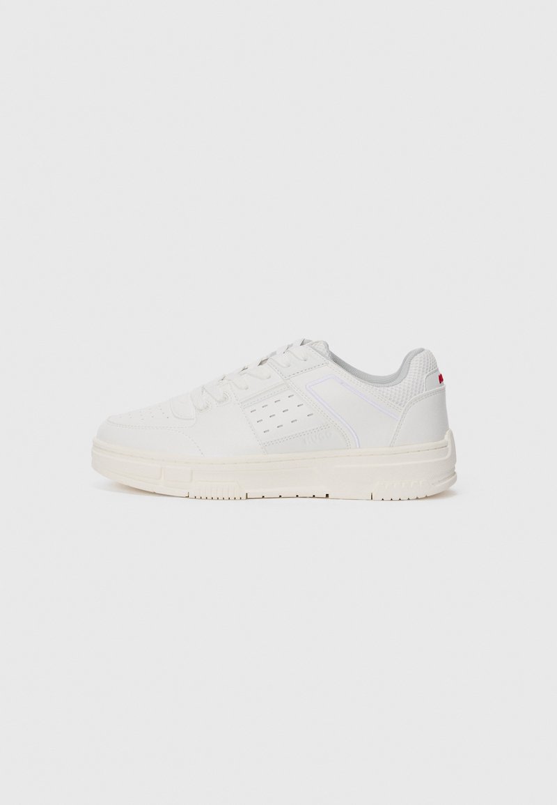 White sneaker with a textured upper, perforated detailing, a light grey mesh tongue, and a cream rubber sole. Features minimal branding on the side.