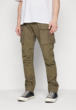Pantaloni cargo verde oliva con multiple ampie tasche, realizzati in un tessuto leggero, con una vestibilità affusolata e dettagli di cucitura discreti.