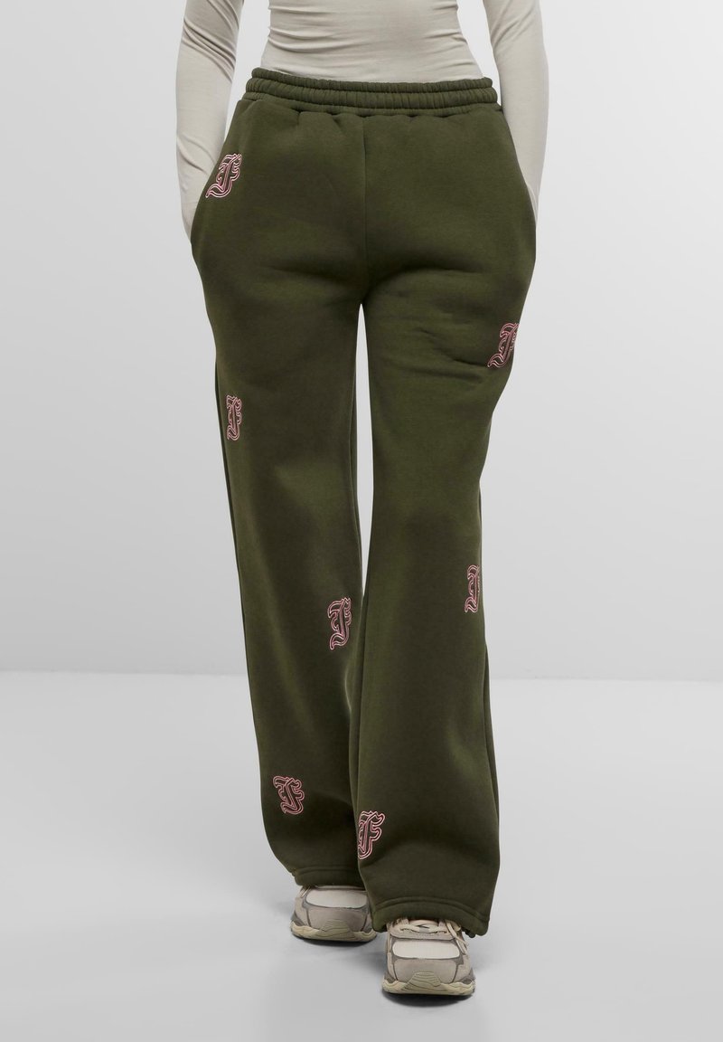 Olijfgroene joggingsbroek met een relaxte pasvorm. Voorzien van een verstelbare tailleband en roze geborduurde logo's verspreid over de bovenbenen. Zachte textuur.