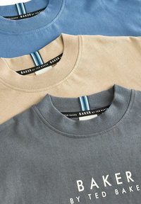 Medvilniniai marškiniai mėlynos, smėlio ir pilkos spalvų. Kiekvienas turi kultivuotą apvalų kaklą ir kontrastingą juostelę su ženklu "BAKER by TED BAKER".