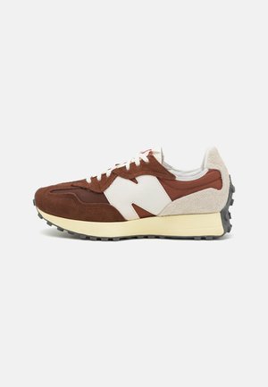 Zapatillas de ante marrón con acentos en blanco, que presentan un panel de malla, un diseño retro y una suela intermedia gruesa de color crema con una suela exterior de goma negra texturizada.