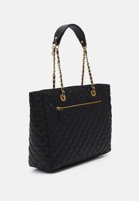 Borsa a tote nera trapuntata con manici in catena dorata, tasca frontale con zip e dettagli in pelle liscia. Presenta una forma strutturata e una finitura testurizzata.