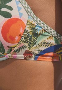 Bikini gornji dio s vibrantnim uzorcima voća i tropskog lišća u zelenoj, ružičastoj i narančastoj boji, s detaljima u zlatnoj boji i teksturiranim rubom.