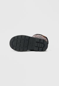 Botas de inverno para crianças com sola de borracha preta e parte superior de tecido floral rosa, mostradas de baixo num fundo branco.