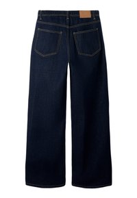 Tamsiai mėlyni, platėjančios kelnės iš džinso audinio. Turi aukštą liemenį, du užpakalinės kišenes ir kontrastingas siūles. Užpakalinėje dalyje yra paprasta rudos odos etiketė.