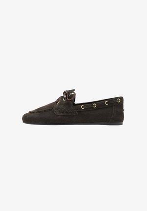 Mocassin en daim marron foncé avec détail en lacets en cuir et œillets dorés, semelle plate et devant cousu style mocassin.