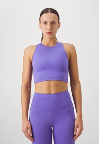 Violetti urheilu crop-top ja korkeavyötäröiset leggingsit sileästä, joustavasta kankaasta. Suunnittelussa on urheilullinen takaosa ja istuva muotoilu.