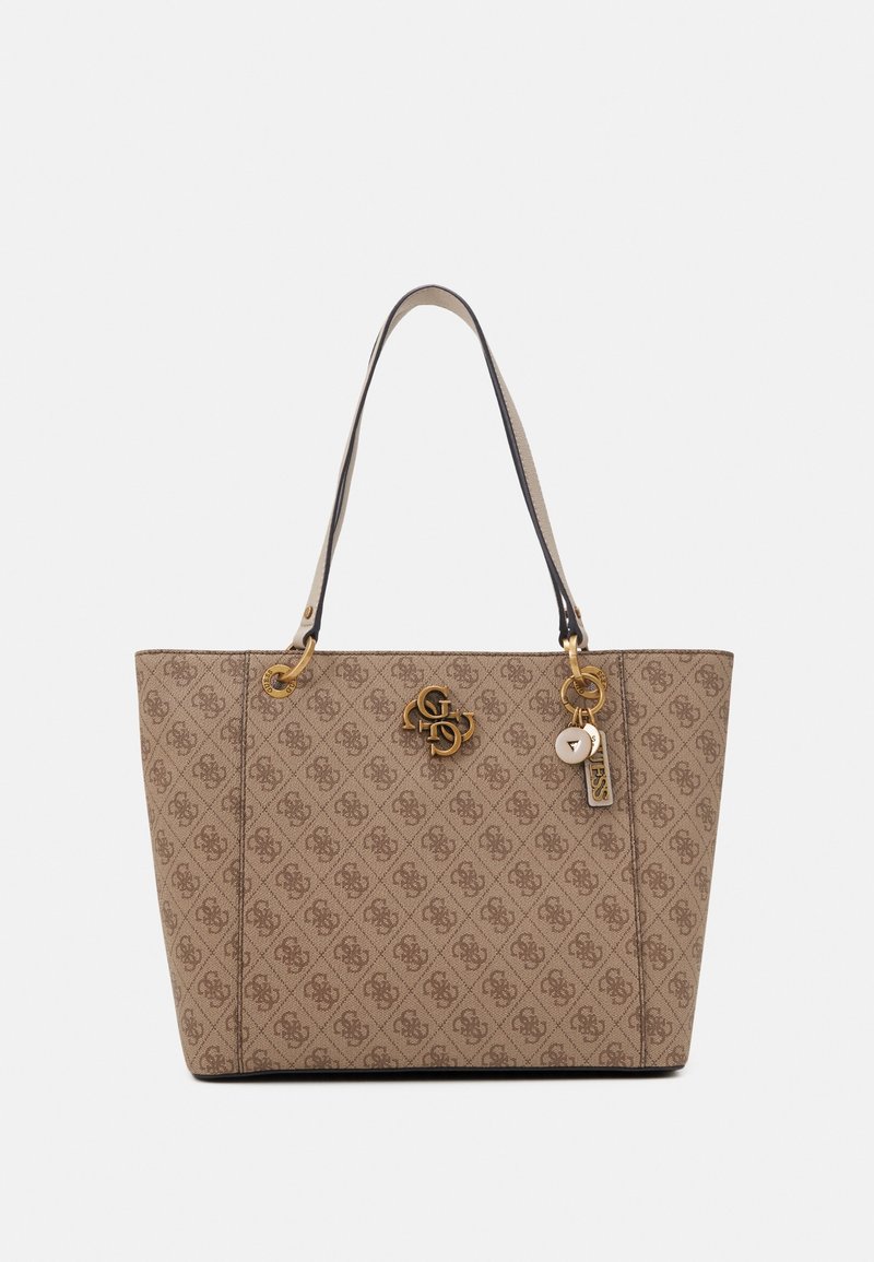 Sac cabas beige avec logos brun foncé à motifs, ferrures dorées, deux bretelles et breloques décoratives suspendues sur le côté droit.