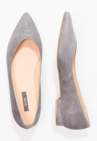 Grå mocka ballerinaskor med spetsig tå, låg bakkant och en liten, fyrkantig klack. Har en slät, nude innersula.