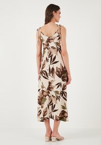 Beige kukkakuosi mekko ruskeilla ja vihreillä lehväkuvioilla. Sisältää säädettävät solmimisnauhat ja mukavan, keskipitkän muotoilun.