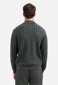 Gebreide donkergrijze polo trui met een verticale ribbelstructuur en een comfortabele pasvorm. Afgewerkt met een klassieke kraag en elastische manchetten.